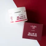 Crema drenante Blue B Breeze Re9va di Linea55 con barattolo bianco da 250ml su sfondo bicolore bianco e rosso.