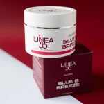 Dettaglio del tappo e dell'etichetta della crema drenante Blue B Breeze Re9va di Linea55 con mirtillo nero su sfondo rosso intenso.