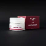 Vasetto da 50ml e confezione bordeaux della crema viso Harmonia Re9va di Linea55 con Argan e plancton marino su sfondo nero.