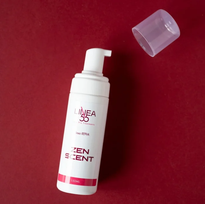 Flacone con dispenser da 150ml di mousse detergente Zen Scent Re9va di Linea55 con cappuccio trasparente aperto su sfondo rosso.
